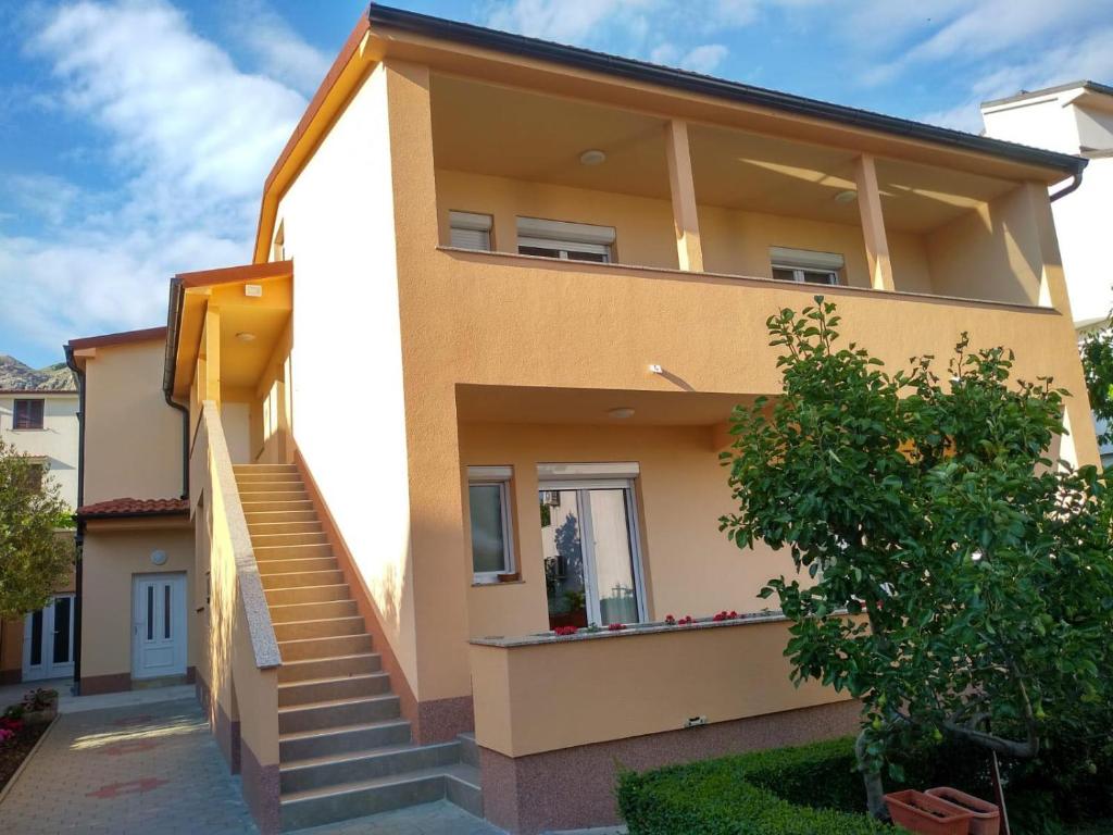 a house with stairs in front of it at Apartments Cizmesija in Baška
