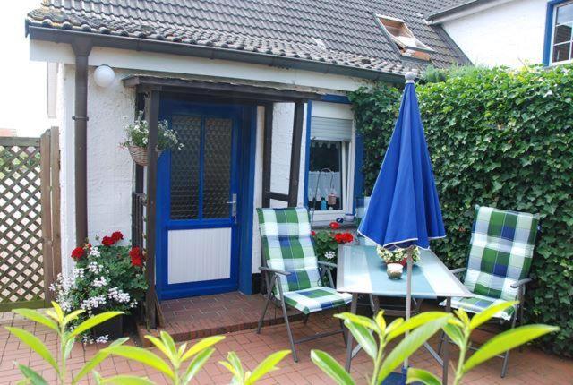 a blue door and two chairs and a table with an umbrella at Schlichte in Kirchdorf