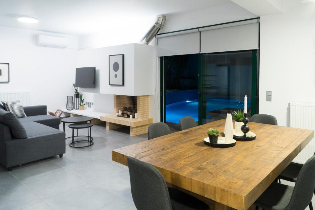 a living room with a wooden table and a couch at The H Experience - The Blue Lounge with Swimming pool in Porto Rafti