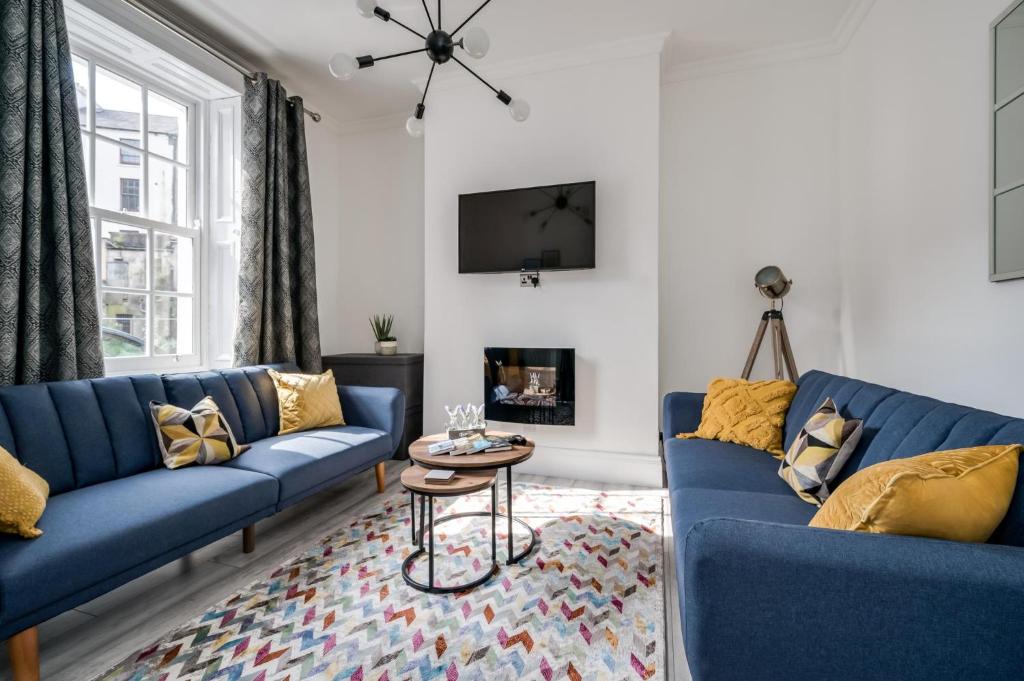 a living room with blue couches and a fireplace at Central Belfast Apartments: Georgian House in Belfast