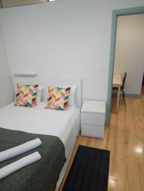 een slaapkamer met een bed met 2 kussens en een tafel bij Near River 63 in Vila Nova de Gaia