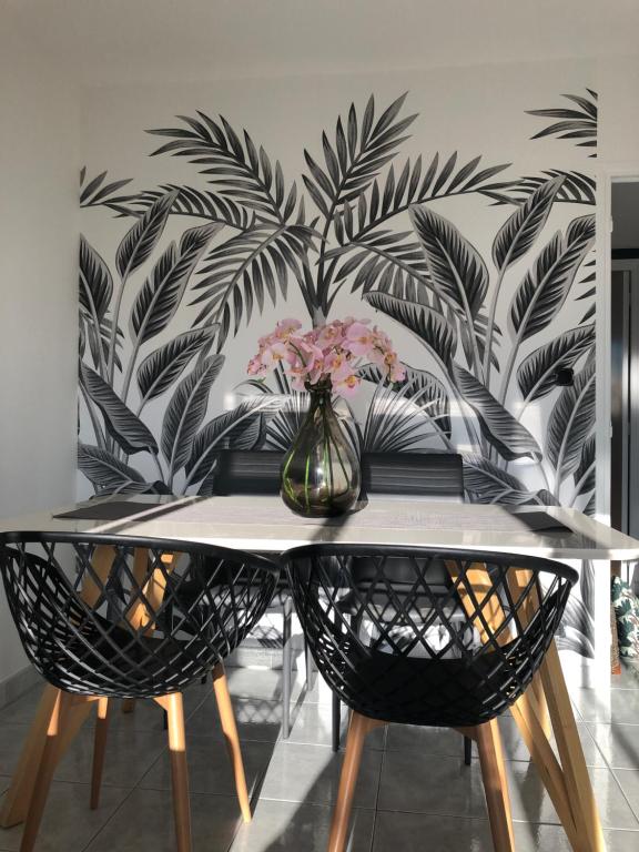 una mesa de comedor con un jarrón de flores en la pared en Le Beauvallon, en Antibes