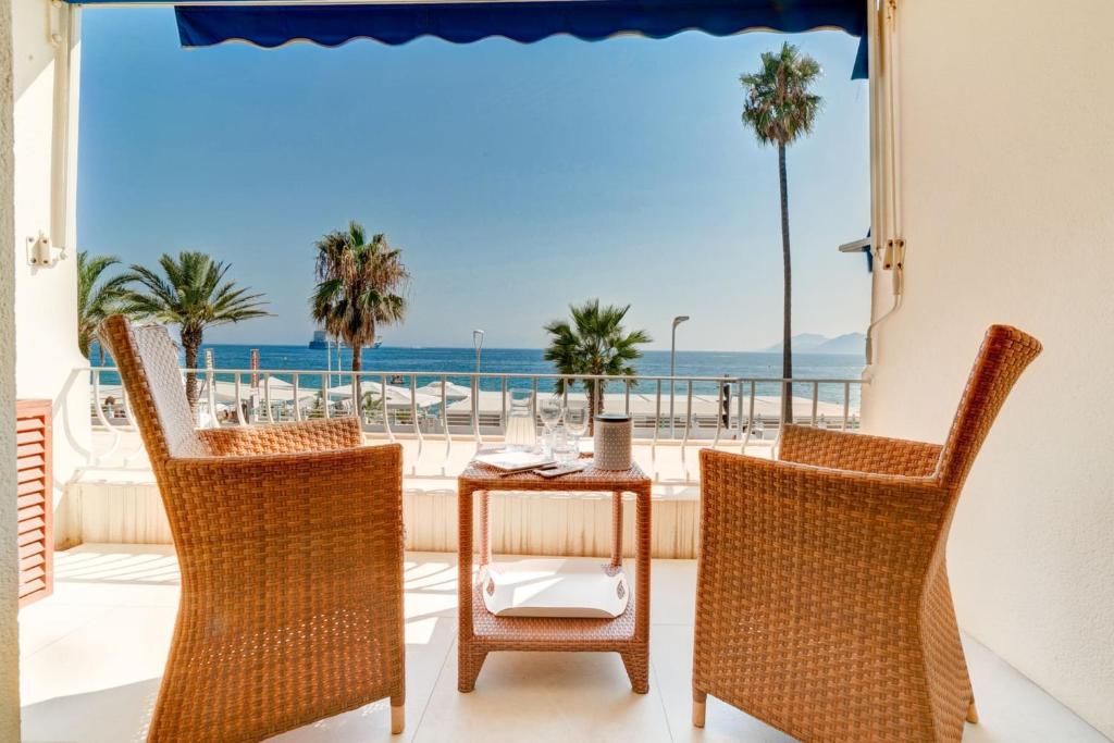 balcón con mesa, sillas y vistas al océano en IMMOGROOM - 3 Sea view Panoramic terrace - 1 min beach - CONGRESSBEACH, en Cannes