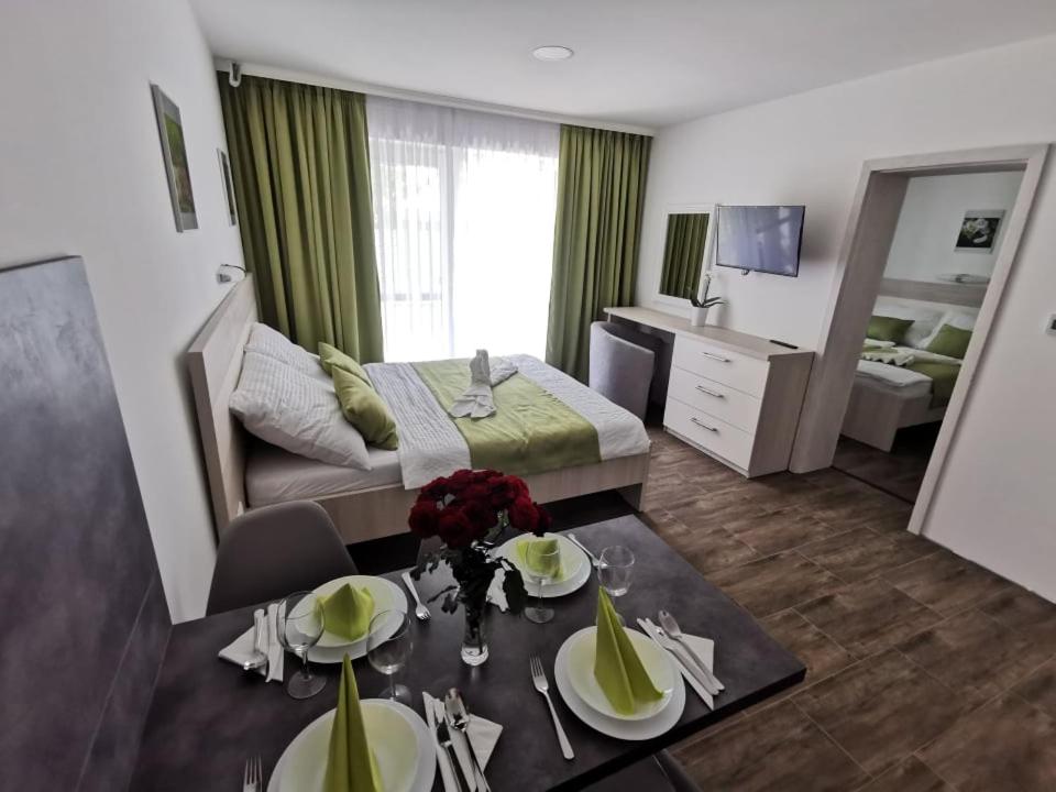 a hotel room with a bed and a dining table at VILLA MEGER in Veľký Meder