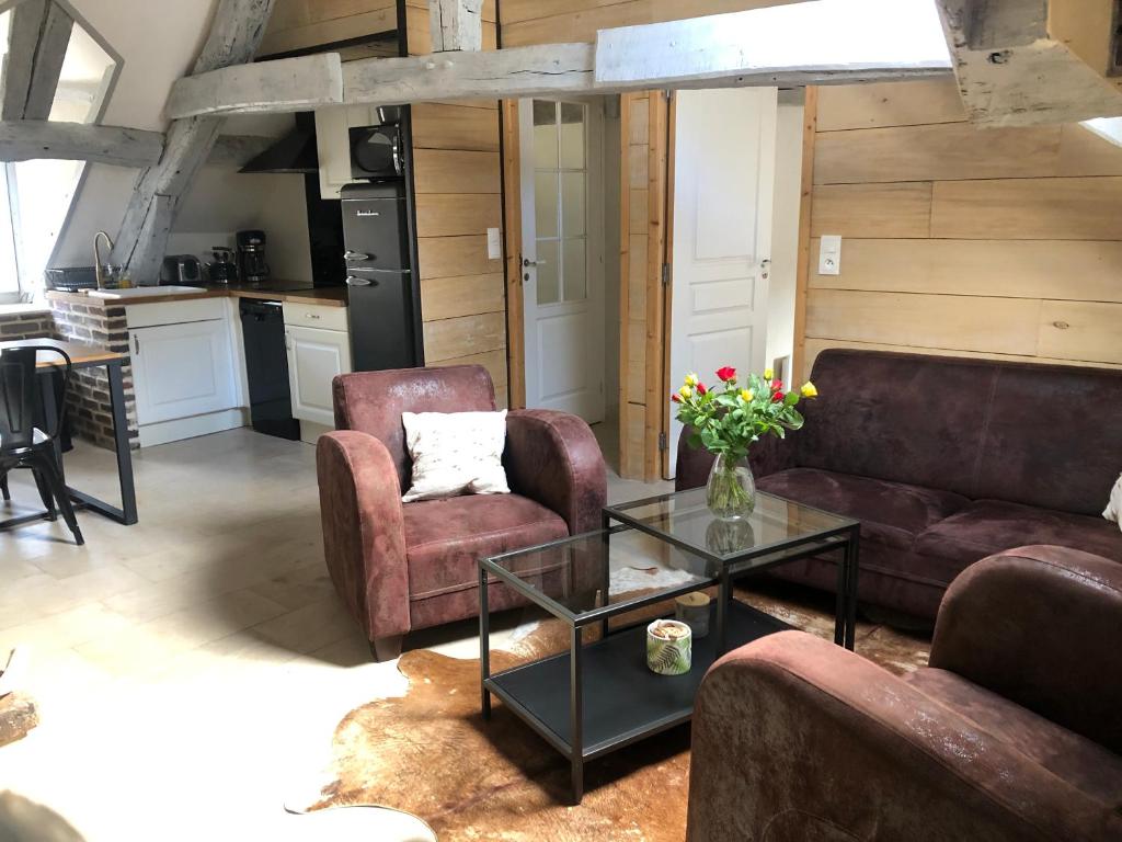 een woonkamer met 2 banken en een glazen tafel bij L'envie d'ailleurs in Honfleur