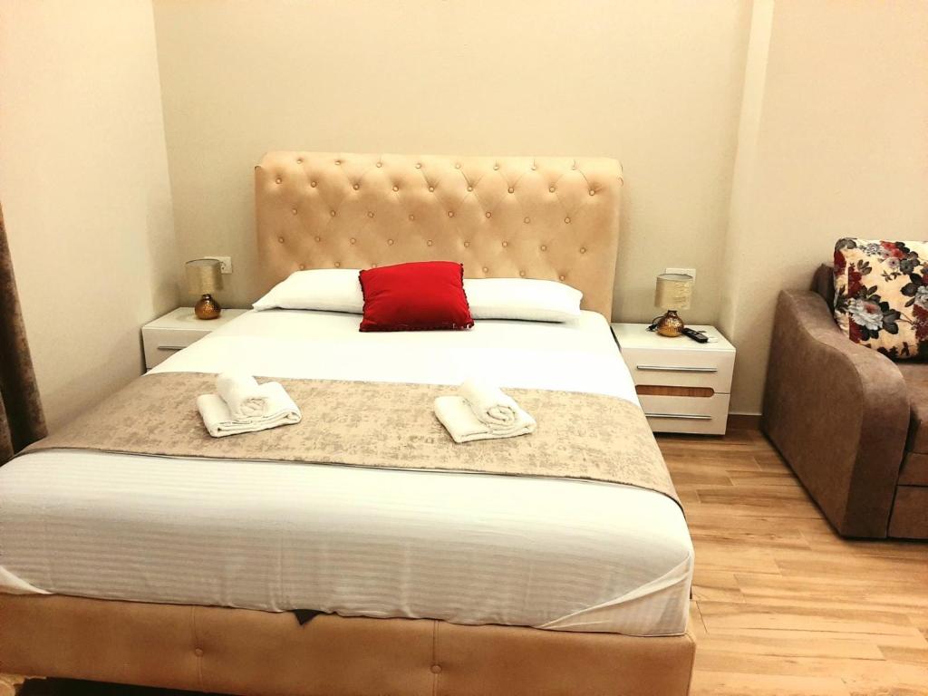 a bedroom with a large bed with a red pillow at Apolon Apart in Bar, Susanj