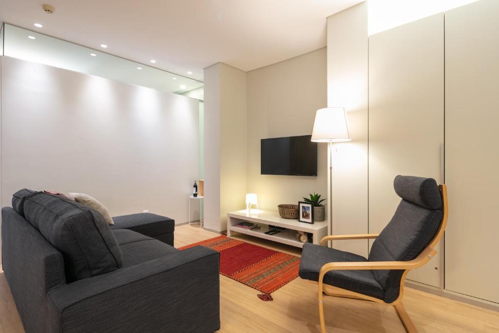 波多的住宿－Oportments - Oliveiras，客厅配有两把椅子和电视