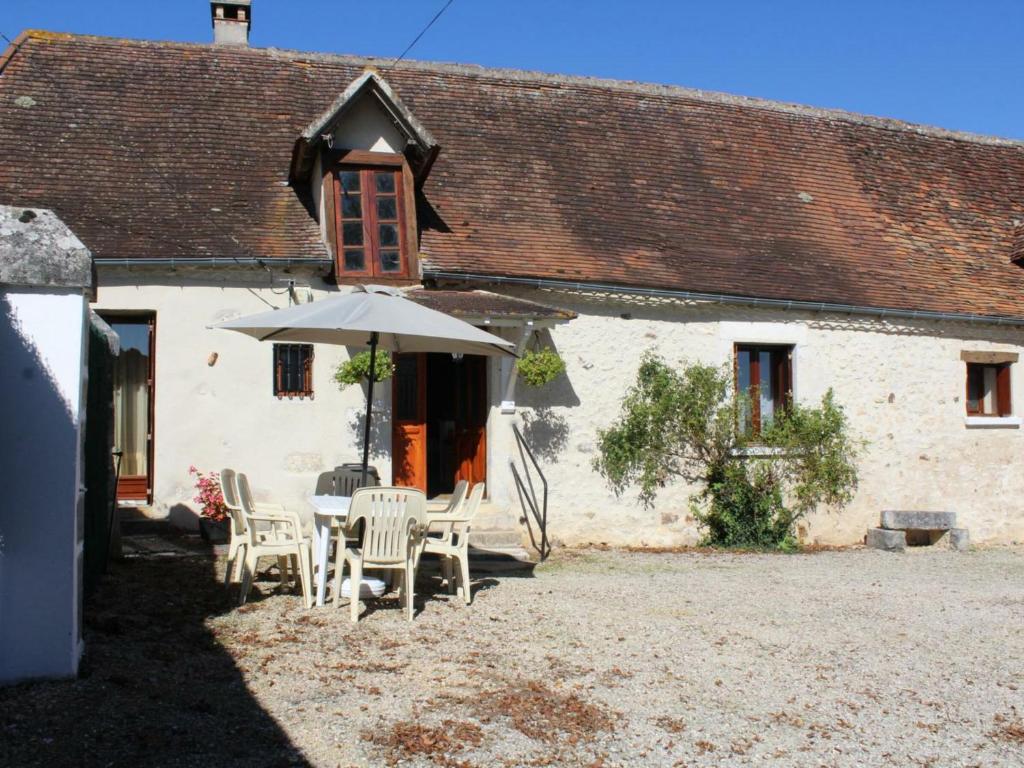 a table and chairs with an umbrella in front of a building at Gîte Fossemagne, 4 pièces, 5 personnes - FR-1-616-113 in Fossemagne