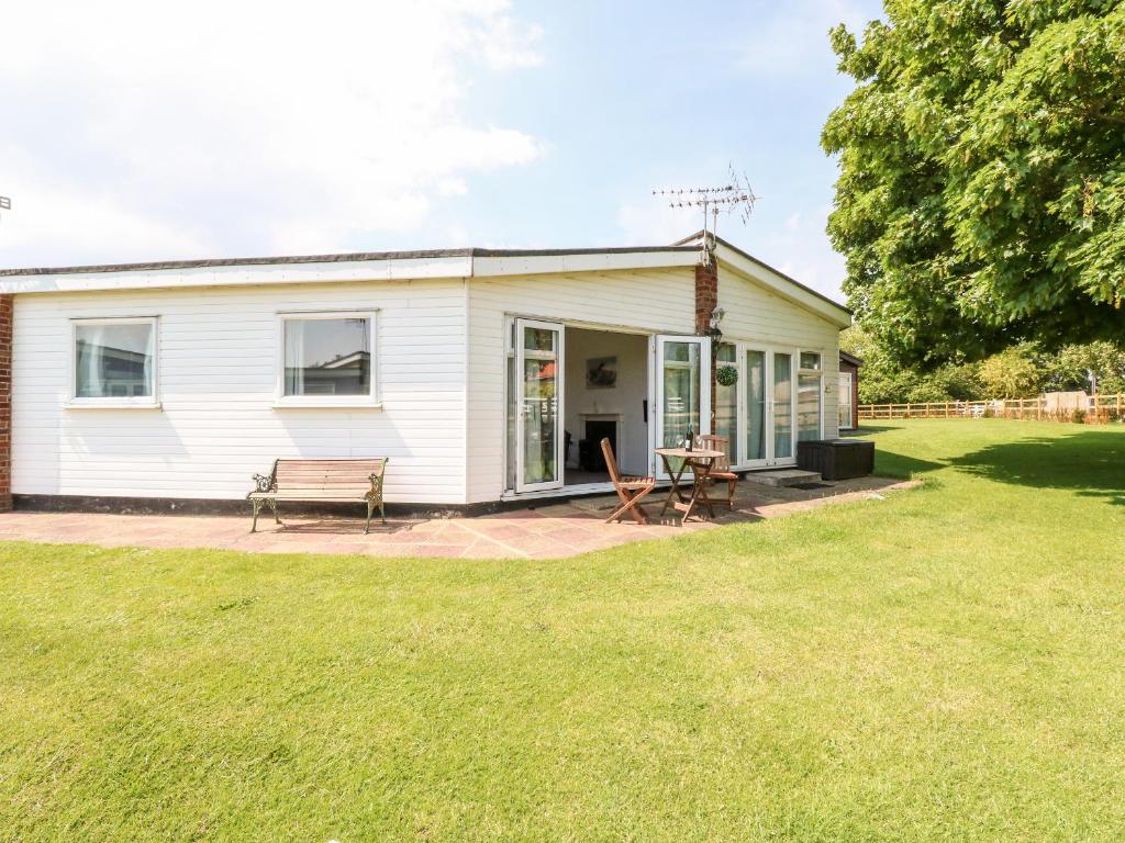 a white house with a picnic table in the yard at Chalet 150 in Great Yarmouth