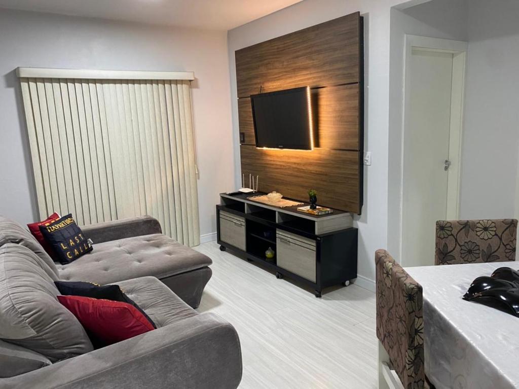 a living room with a couch and a flat screen tv at LINDO APARTAMENTO 1822 in Balneário Camboriú