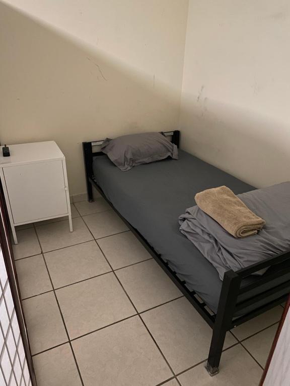 a small room with a bed and a night stand at Private Cubicle - Single Bed - Mixed Shared Dorm - MIAMI AIRPORT in Miami