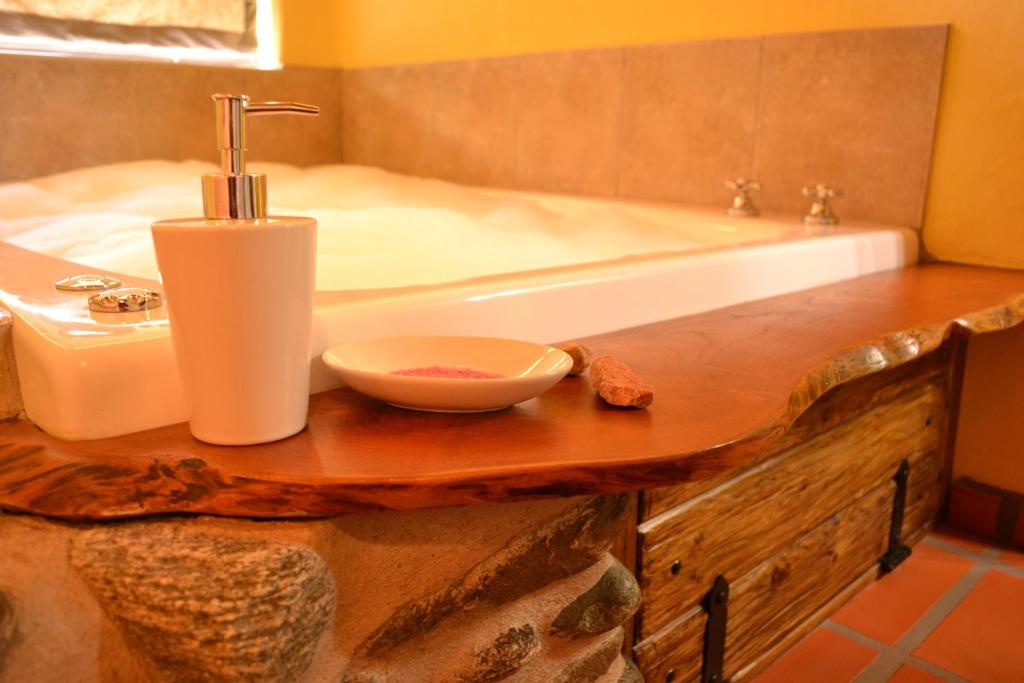 y baño con bañera, lavabo y bol. en Cabañas Chacras del Arroyo Vidal en Carpintería