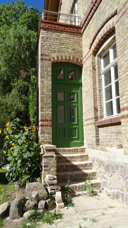 una puerta verde al lado de un edificio de ladrillo en FeWo "Falter" im Kunstgut Krahne, en Krahne