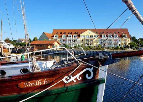 a boat is docked in a marina with buildings in the background at Seepanorama 1 in Kirchdorf
