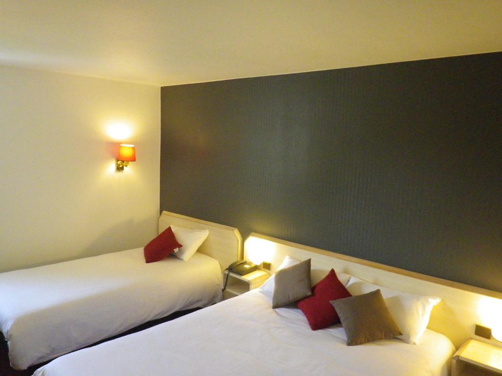 Postel nebo postele na pokoji v ubytování Hotel Amys Voreppe