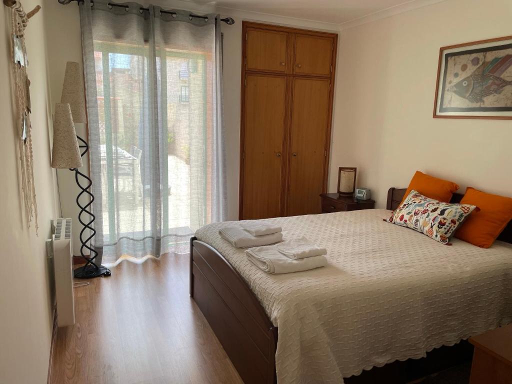 um quarto com uma cama e uma grande janela em Verde Ria apartamento em Torreira