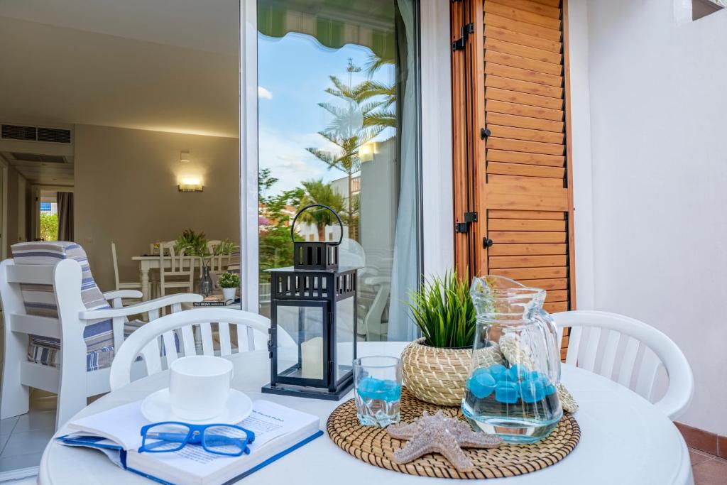 una mesa blanca con gafas y una cesta en ella en Apartamentos Estival Park, en La Pineda