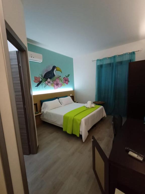 a bedroom with a bed with a bird painting on the wall at Sweet Dreams in San Vito lo Capo