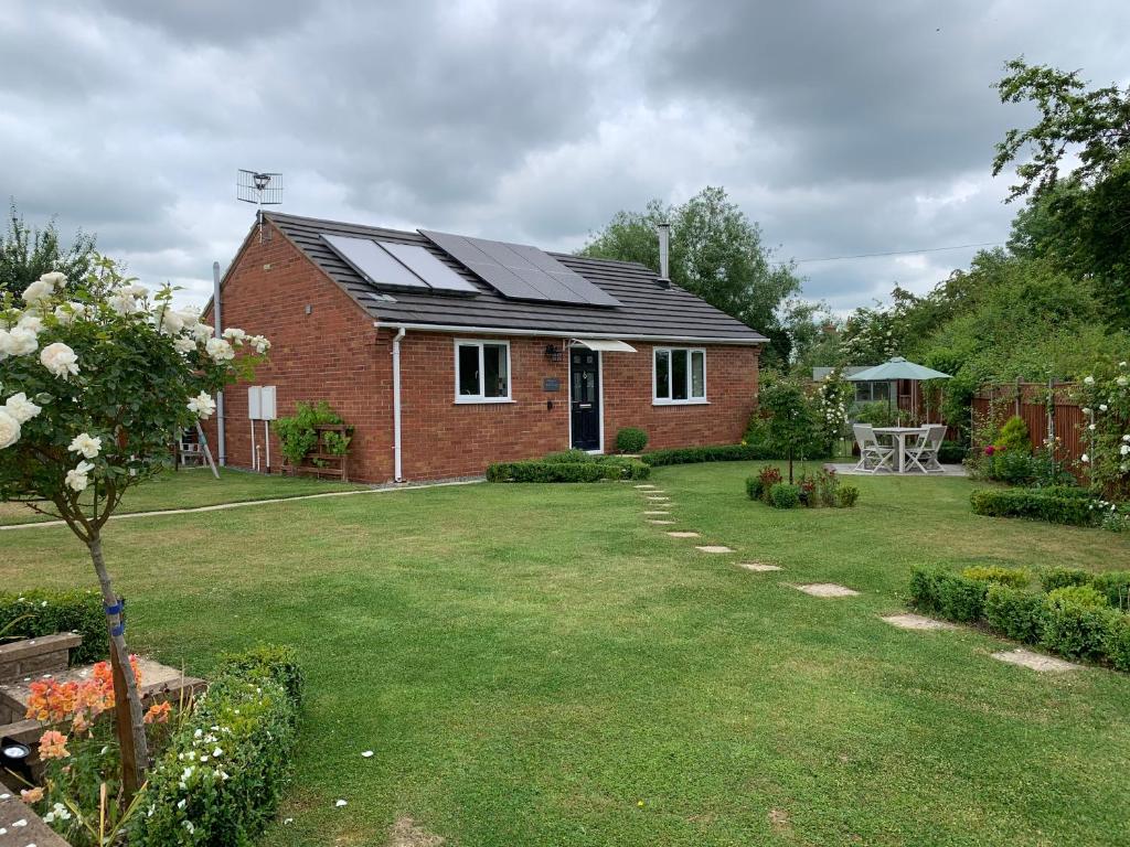 a red brick house with solar panels on the roof at The Hideaway in Stratford-upon-Avon