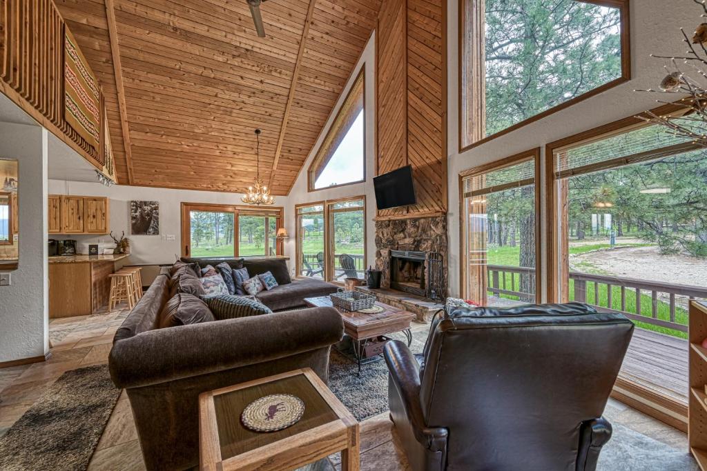 ein großes Wohnzimmer mit einer gewölbten Decke und Fenstern in der Unterkunft Mountain View Cabin in Angel Fire