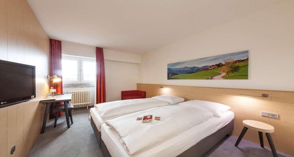 a hotel room with a bed and a flat screen tv at Sure Hotel by Best Western Muenchen Hauptbahnhof in Munich