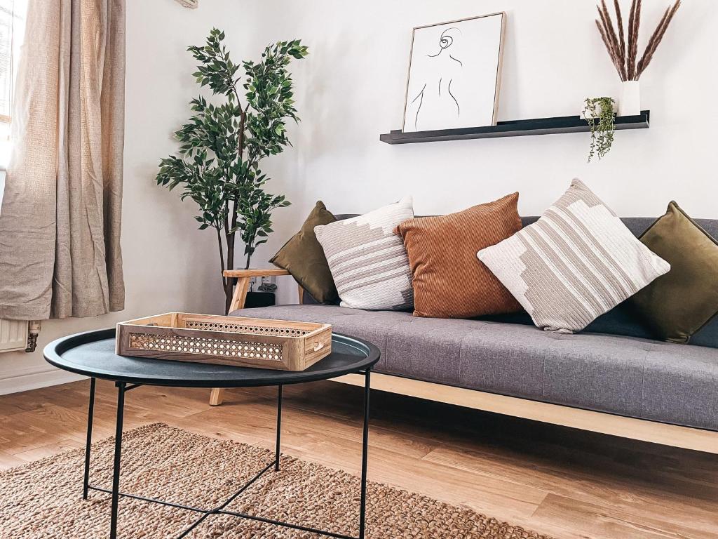 sala de estar con sofá con almohadas y mesa en Hollybush Apartment, by Solace Stays en Newport