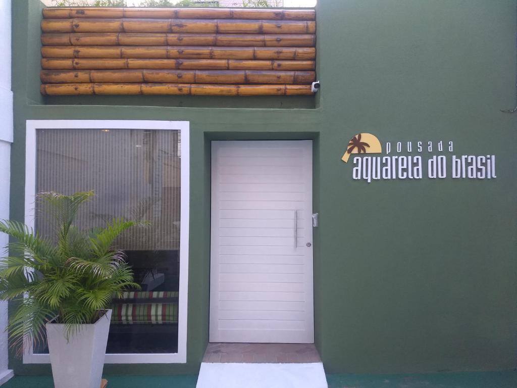 un edificio con una puerta blanca y una maceta en Pousada Aquarela Do Brasil, en Maceió