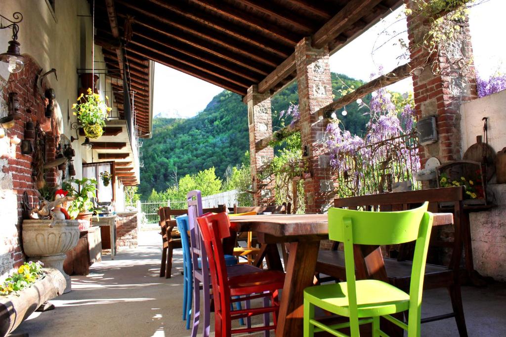 a wooden table with colorful chairs on a patio at Lu Garun Rus in Valdieri