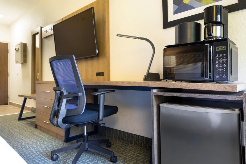a room with a desk with a chair and a microwave at Holiday Inn Express San Jose Costa Rica Airport by IHG in Alajuela City