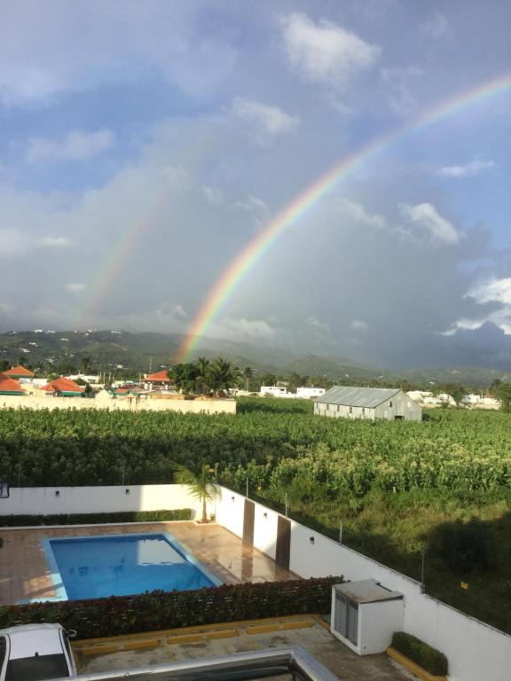 einen Regenbogen über einem Haus mit Pool in der Unterkunft My Beautiful Place in Santiago de los Caballeros