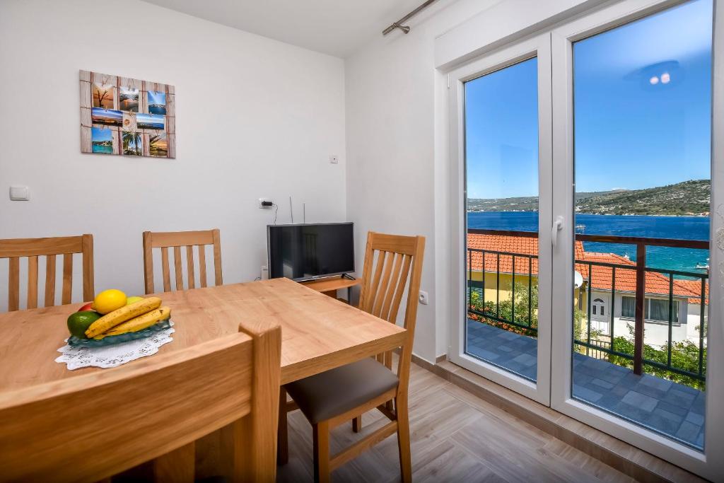 a dining room with a table and a view of the ocean at Apartments Ruza in Ražanj
