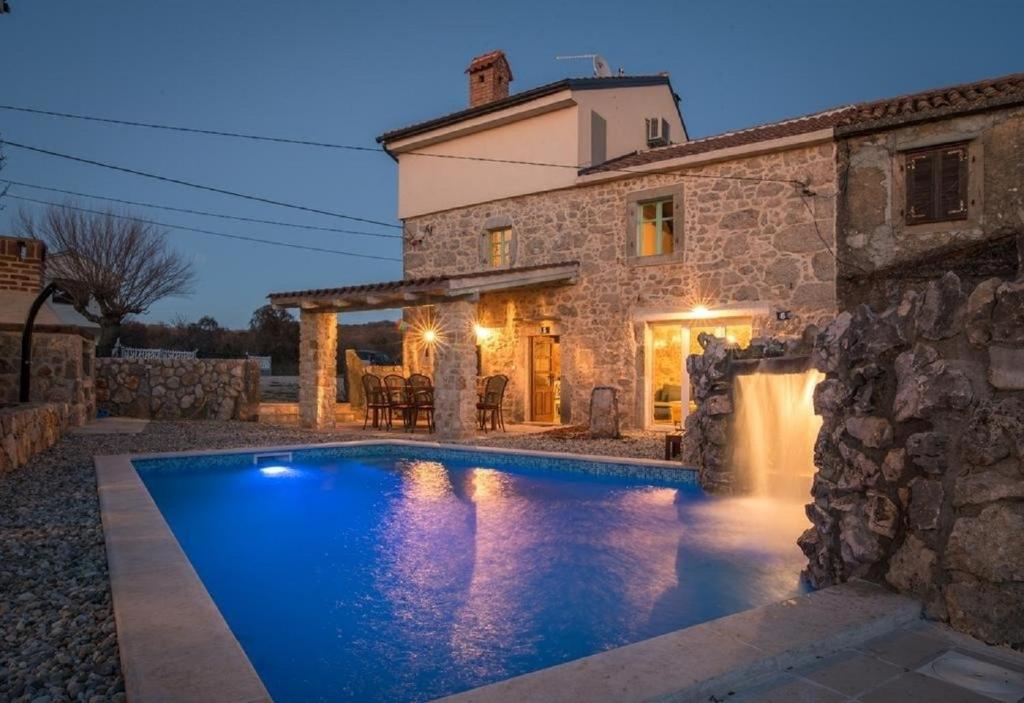 a house with a swimming pool in front of a building at Villa Frank - with pool in Vrbnik