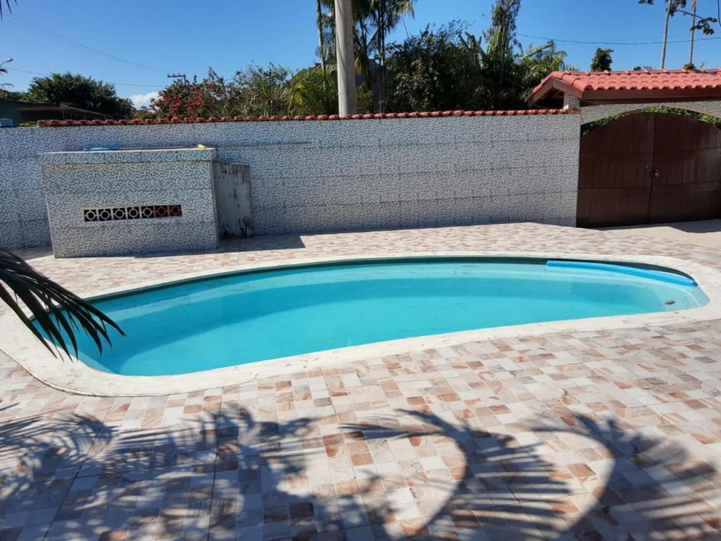 una piscina di fronte a un muro di mattoni di Casa de praia Boracéia a Bertioga