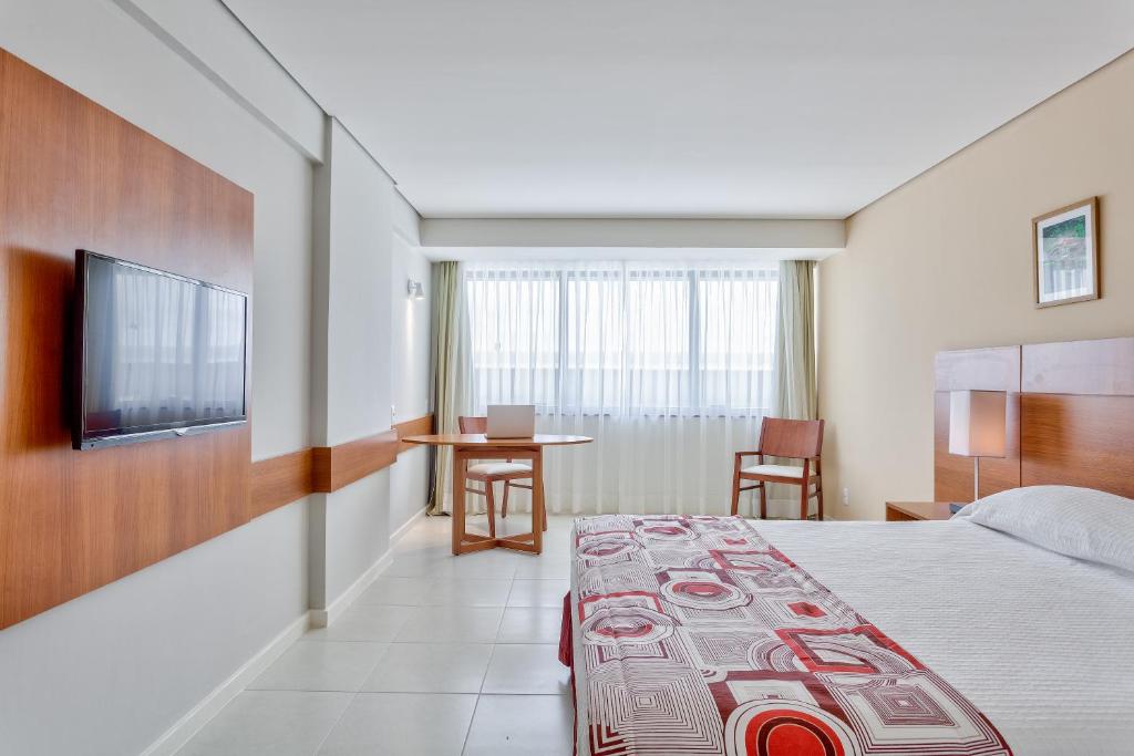 um quarto de hotel com uma cama e uma televisão de ecrã plano em Best Hotel Sobral em Sobral