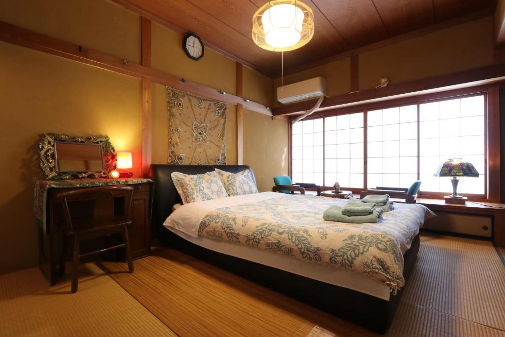 1 dormitorio con cama, espejo y ventana en Shanti House Sakaiminato, en Sakaiminato