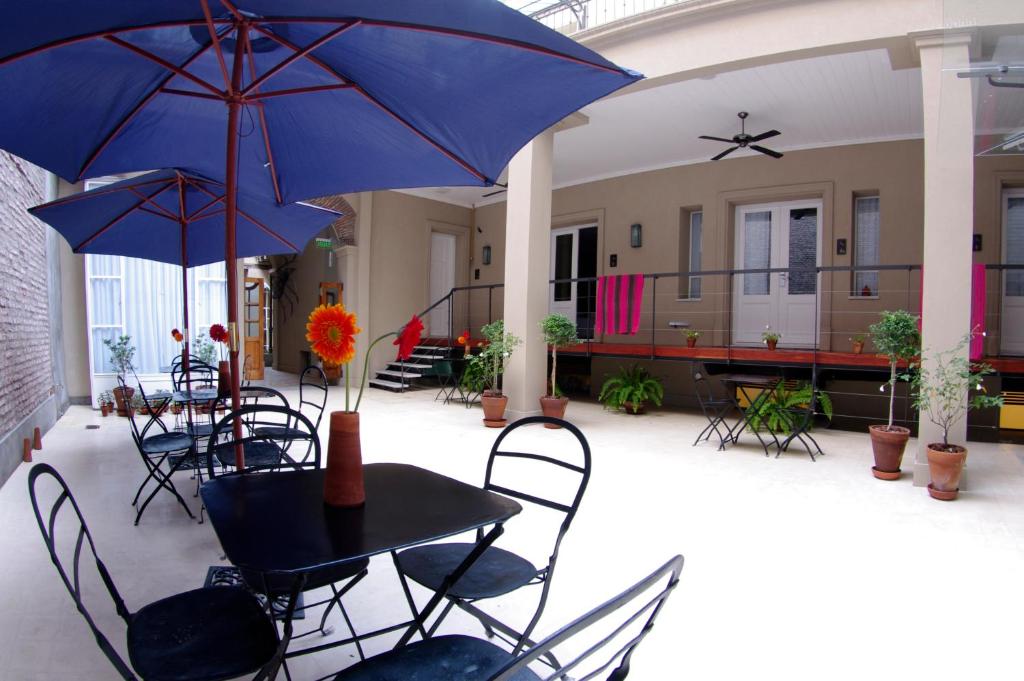 eine Terrasse mit Tischen, Stühlen und Sonnenschirmen in der Unterkunft Patios de San Telmo in Buenos Aires