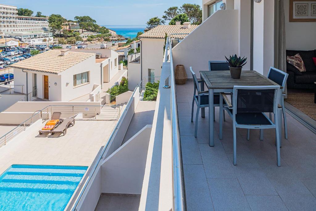balcón con mesa y piscina en MOLINS 4, en Cala de Sant Vicent
