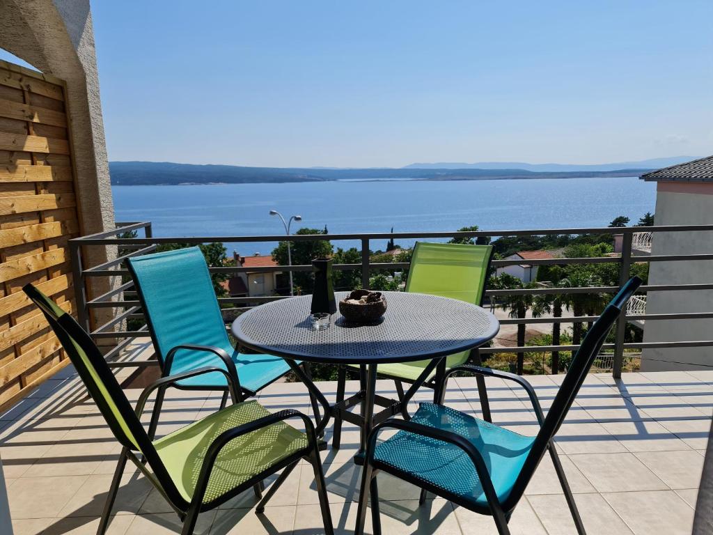 a table and chairs on a balcony with a view of the water at Apartments Lounger Crikvenica in Crikvenica