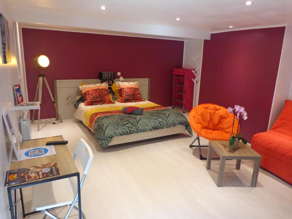 a bedroom with a bed and an orange chair at Chambres d'hôtes les 2G in Boësse