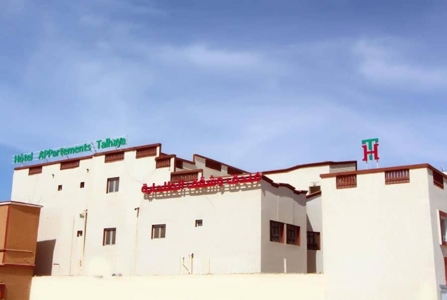 Hotel Suites TALHAYA, NOUAKCHOTT في نواكشوط: مبنى ابيض فوقه صليب