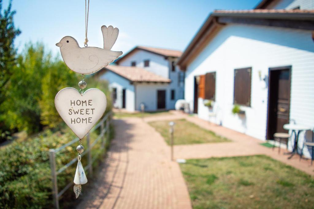 un signo en forma de corazón con un pájaro en una casa en La Valle Dei Caprioli Village Bungalow Park - Freelandia Azienda Agricola en Montescudo