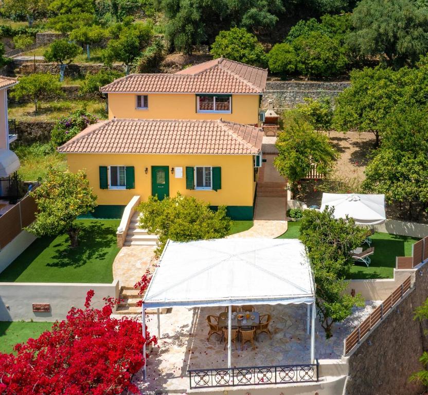 eine Luftansicht eines gelben Hauses mit Garten in der Unterkunft Avrochares Villa in Zakynthos