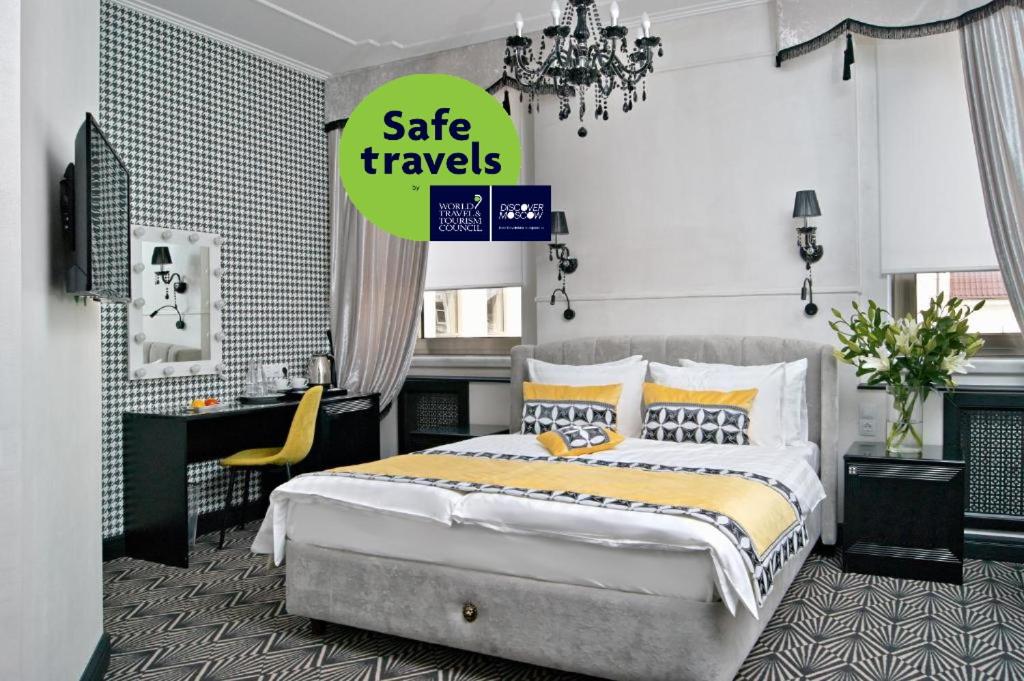 a bedroom with a bed and a sign sale travels at Design Hotel Sofit in Moscow