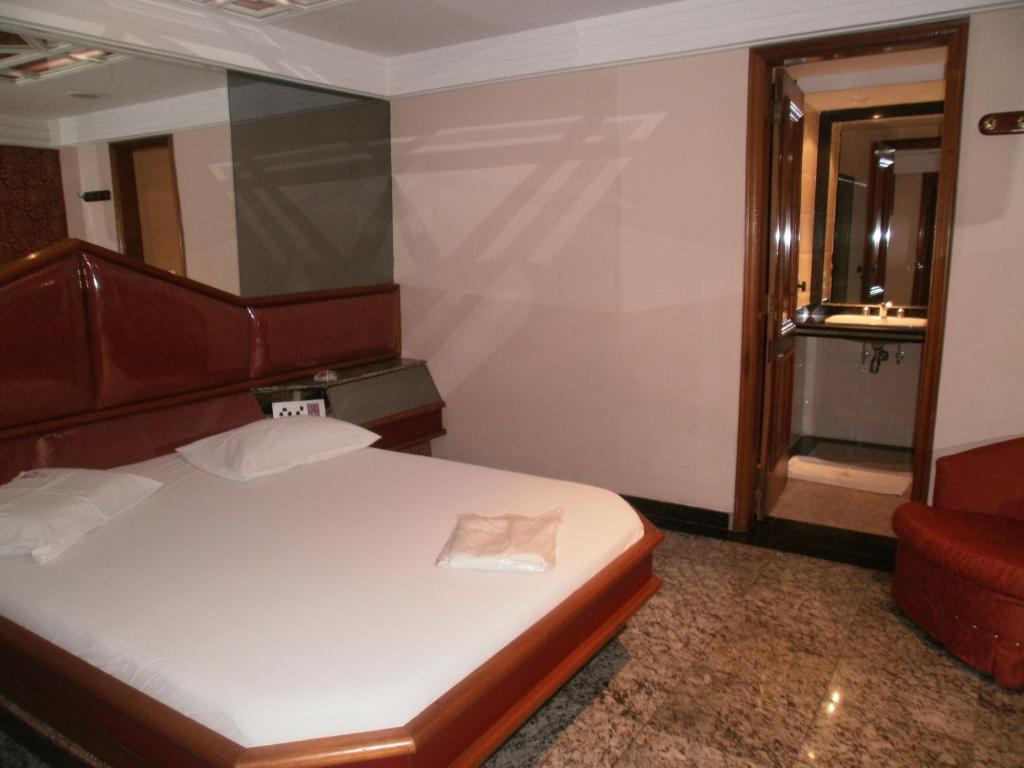 a small bedroom with a bed and a chair at Te Adoro Hotel (Adult Only) in Rio de Janeiro