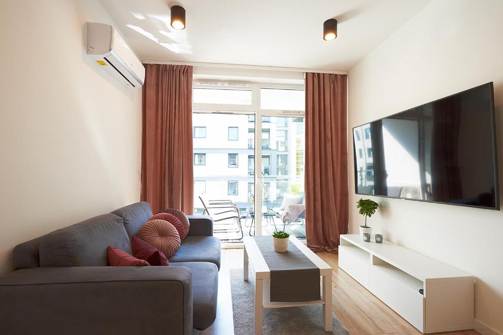 Televízia a/alebo spoločenská miestnosť v ubytovaní Apartament Dębowiec