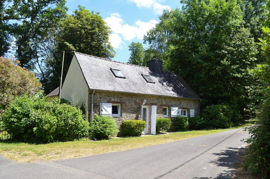 ein kleines Steinhaus am Straßenrand in der Unterkunft Lodge Kervoazec - Château de Kervoazec in Saint-Goazec