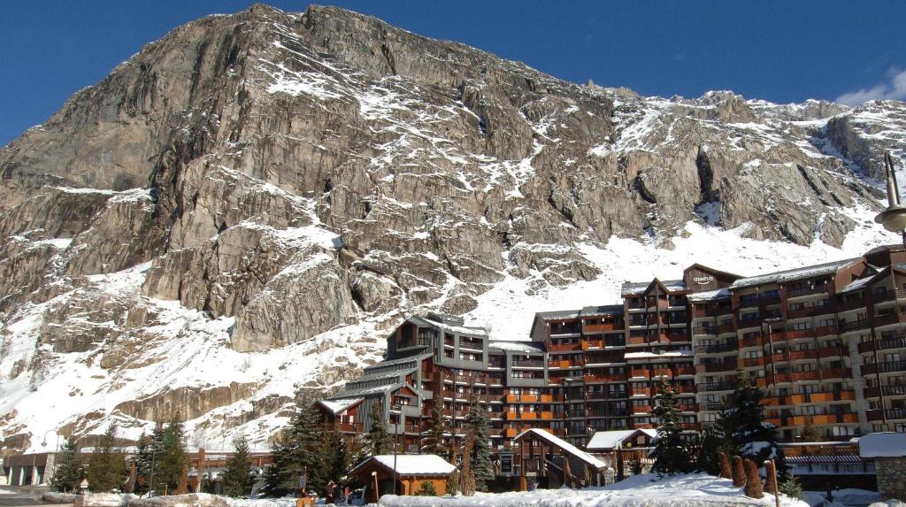 a building in front of a mountain with snow on it at Résidence La Daille - Val-d’Isère in La Daille