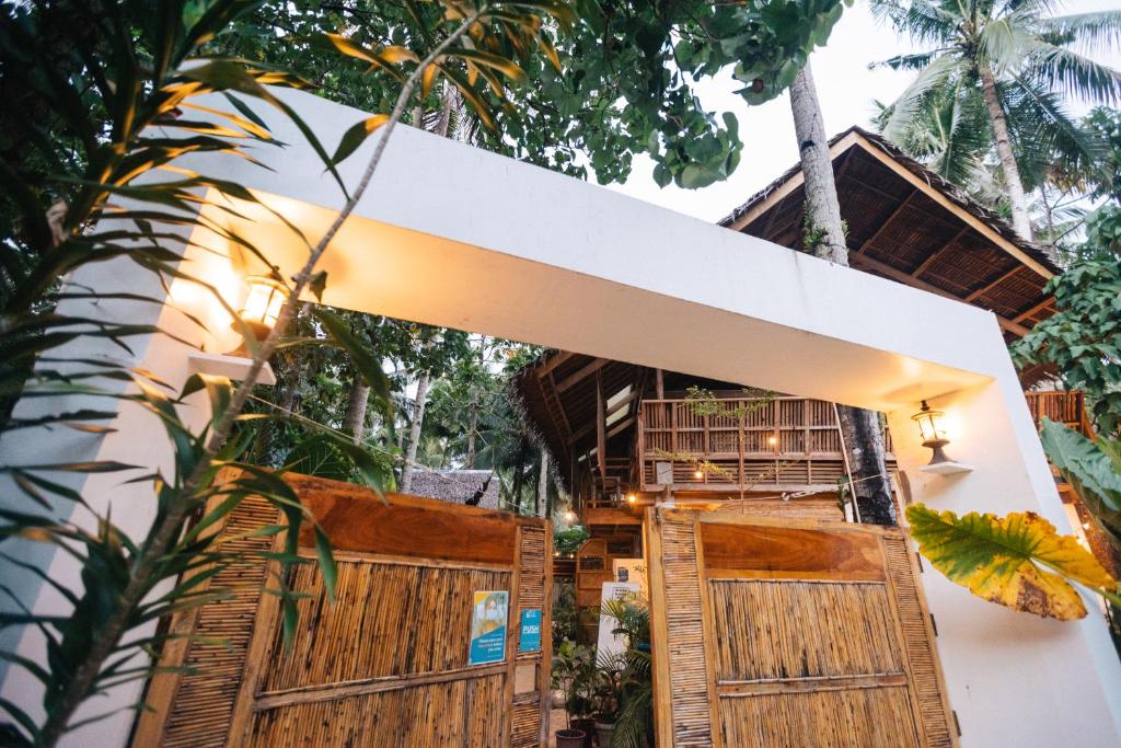 a house in the jungle with wooden doors at Higala Hostel Siargao in General Luna