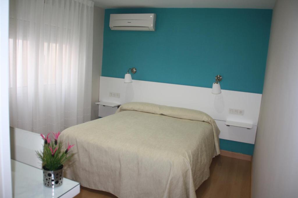 1 dormitorio con cama y pared azul en Verona, en Granada