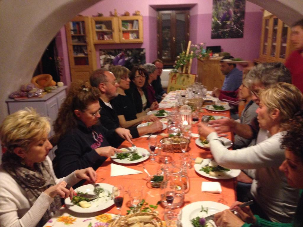 Eine Gruppe von Menschen, die an einem langen Tisch sitzen und Essen essen. in der Unterkunft Agriturismo Zafferano e Dintorni in SantʼAnatolia di Narco